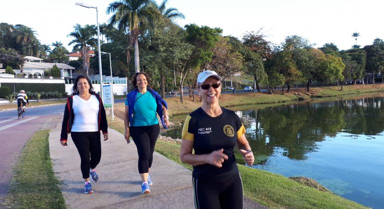 Programa Caminhar oferece avaliação física e orientações a praticantes de caminhada e outras atividades. Foto: Vilma Tomaz Três mulheres de terceira idade, integrantes do programa Caminhar, andam na orla da Lagoa da Pampulha.