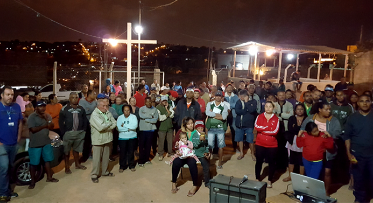 Cerca de cinquenta moradores da Comunidade Dandara em reunião à noite.