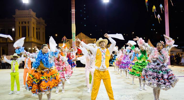 Mais de dez membros do Grupo Recreativo Arraial do Kossaco se apresentam ao lado da Praça da Estação.