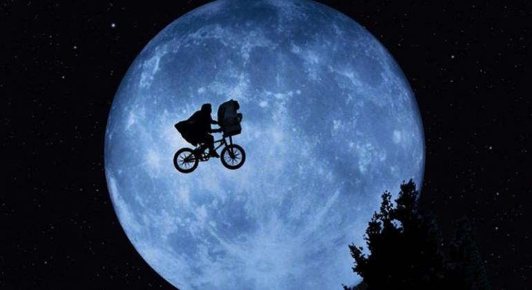 E.T. - O Extraterrestre (Steven Spielberg, EUA, 1982) Imagem de sombra de garoto na bicicleta carregando ET contra a luz da lua, cena clássica de E.T. - O Extraterrestre (Steven Spielberg, EUA, 1982).