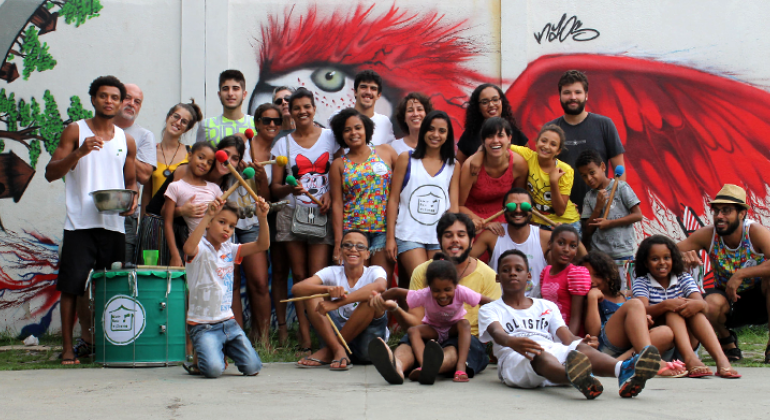 Projeto sociocultural “Seu Vizinho” alia o carnaval à formação e à cidadania no Aglomerado da Serra. Foto: Lucas MIraglia Cerca de vinte jovens reunidos em bloco de carnaval.