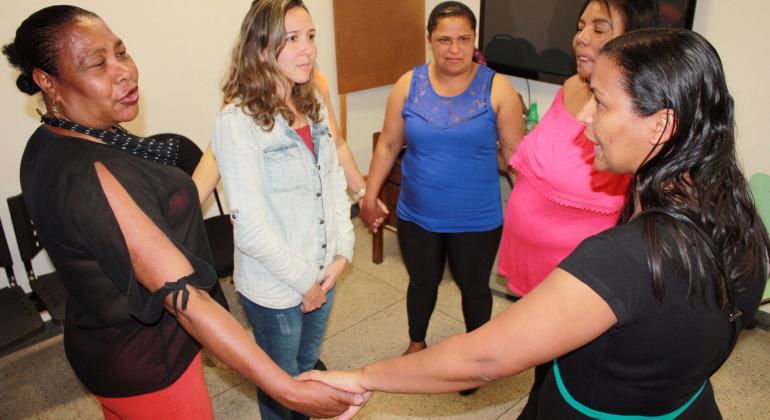 Com encontros semanais, centro de saúde promove Projeto Vida Leve, que incentiva mudança de hábito com grupo de alimentação saudável. Foto: Marina Jordá/PBH Cinco mulheres fazem um círculo e mãos dadas.