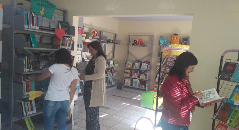 Com a abertura de bibliotecas escolares também aos fins de semana, Prefeitura amplia o acesso à leitura para toda a população. Foto: Magi Mappa/PBH Três pessoas utiizam bilblioteca das ecolas, abertas também nos finais de semana.