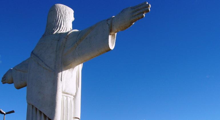 Originada por grandes fazendas, uma das regiões mais antigas de BH destaca-se pelo desenvolvimento e os bens culturais e naturais. Foto: Arquivo Barreiro/PBH Imagem do Cristo do Barreiro de costas. Ao fundo, céu azul em dia claro.