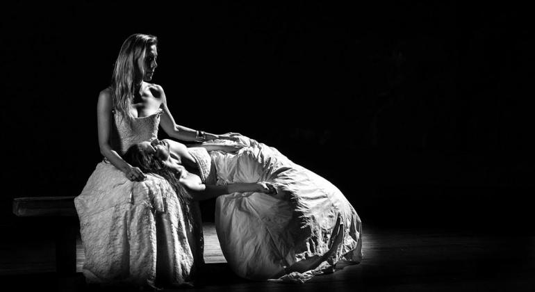 Duas mulheres de vestido branco, uma deitada no colo da outra, em imagem preto e branca. Cena do Filme Dois Casamentos, de Luiz Rosemberg Filho, em cartaz no MIS Cine Santa Tereza.