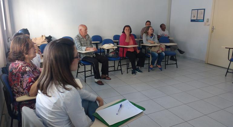 Grupos de prevenção ao tabagismo em centros de saúde ajudam às pessoas em luta contra o vício. Foto: Guthemberg Moraes/PBH Sete pessoas se reúnem em sala de centros de saúde na luta contra o tabagismo.