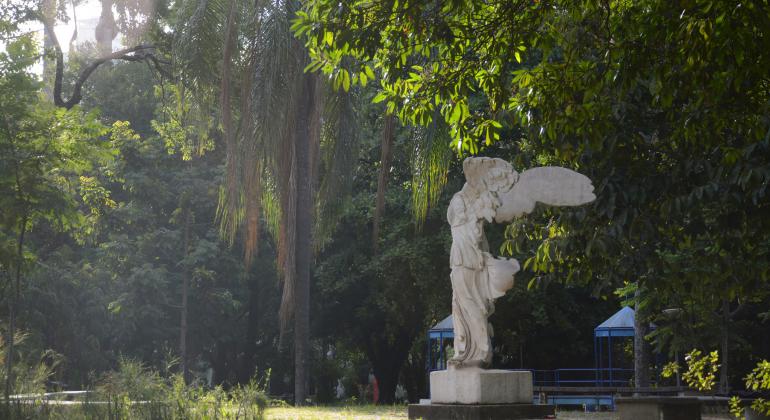 Parque Municipal Américo Renneé Giannetti, com muito verde e estátua de anjo.