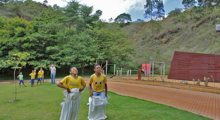 Crianças brincam de corrida do saco no Parque Municipal Serra do Curral.