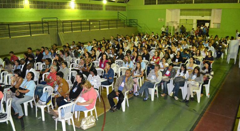 Mais de 50 pessoas sentadas em ginásio escolar, participando de Pré-Conferência Municipal de Políticas sobre Drogas de anos anteriores. Foto Ilustrativa.