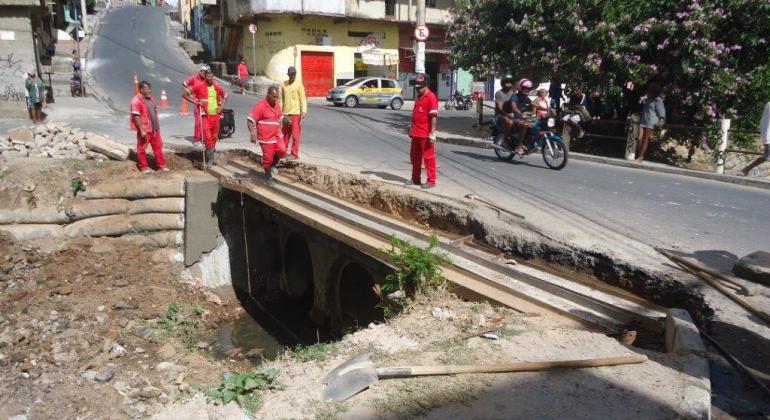 Funcionários da Regional Norte fazem reparo em rua sobre galeria com materiais reciclados.