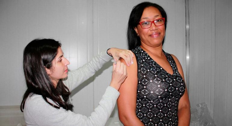 Técnica de saúde vacina mulher adulta.