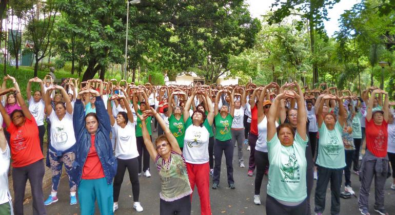Foto: Divulgação PBH Mais de trinta pessoas em parque com as mãos levantadas fazendo movimentos de Liang Gong
