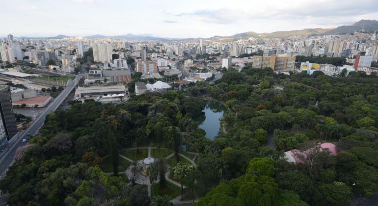 ICLEI se reúne com PBH e municípios da região metropolitana para discutir programa ligado à biodiversidade urbana e meio ambiente. Foto: Amira Hissa/PBH Ambiente urbano de prédios e avenidas divide espaço com o verde do Parque Municipal Américo Renneé Giannetti em foto aérea.