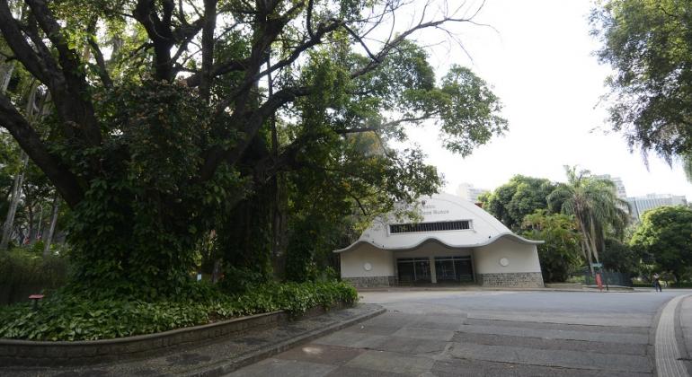 Fachada do Teatro Francisco Nunes com verde à esquerda. 