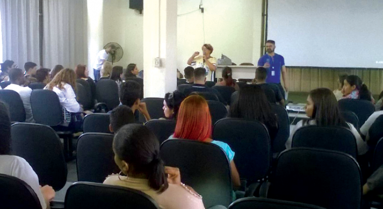 Homem e mulher dão palestra para alunos da Rede Municipal de Ensino.