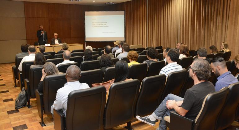 PBH oferece curso sobre gestão cultural e sociedade civil Dois palestrantes ministram cursos para mais de dez pessoas em sala.