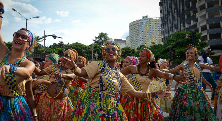 Grupo de mulheres negras dança usando vestimentos afro