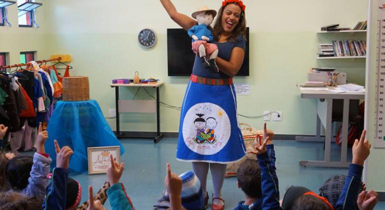 Evento reúne uma série de atividades artísticas e apresentações de espetáculos para celebrar o Dia das Crianças. Foto: Divulgação A contadora Ana Raquel segura um boneco de pano e interage com as crianças.