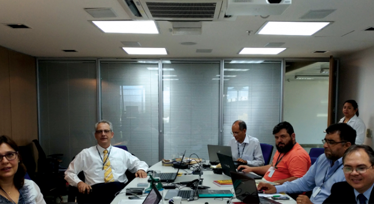 Grupo nacional que irá padronizar as informações de cadastro territorial urbano de todo o Brasil conta com expertise da Prodabel. Foto: Divulgação PBH Cinco funcionários da Prodabel em reunião, sentados em uma mesa.