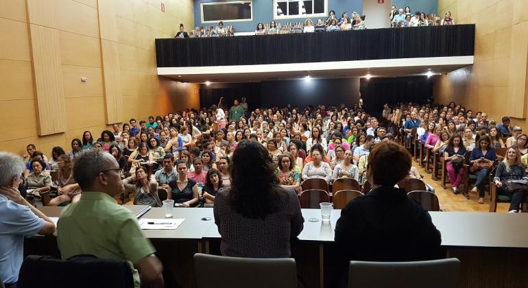 Auditório da Faculdade de Medicina da UFMG recebe o seminário inaugural SUAS Conexões. Foto: Divulgação PBH Três pessoas na mesa de costas, em primeiro plano, e atrás o público de mais de cem pessoas lotando o teatro da Faculdade de Medicina da UFMG