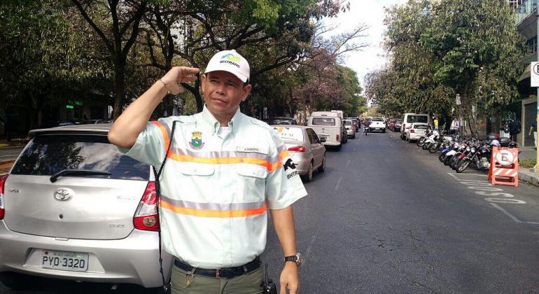 Acompanhe jornada de dois agentes municipais de trânsito de Belo Horizonte e confira números de balanço semestral. Foto: Divulgação PBH Agente de trânsito da BHTrans em rua com movimento de carros durante o dia.