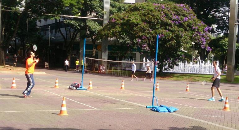 Duas pessoas jogam badminton na Praça da Savassi. 