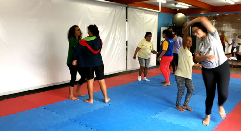 Programa oferece aulas de dança duas vezes por semana para pessoas com deficiência em espaço da região Noroeste. Foto: Vilma Tomaz/PBH Seis jovens fazem aula de dança, reunidos dois a dois.