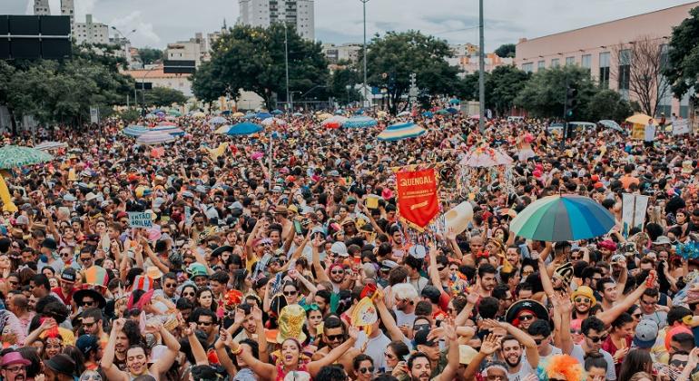 Mais de duzentas pessoas participam do bloco de rua Então Brilha!, na avenida dos Andradas, durante o dia. 