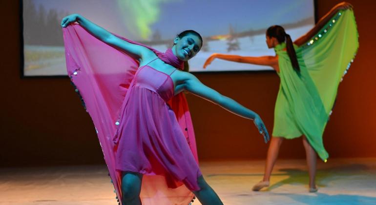 Museu de moda apresenta espetáculo de dança “Conexões Contemporâneas”, que aborda a questão da sustentabilidade, de 20 a 21 de outubro. Foto: Divulgação Duas mulheres, uma de rosa e outra de verde, dançam; ao fundo, um telão com imagens de vídeo.