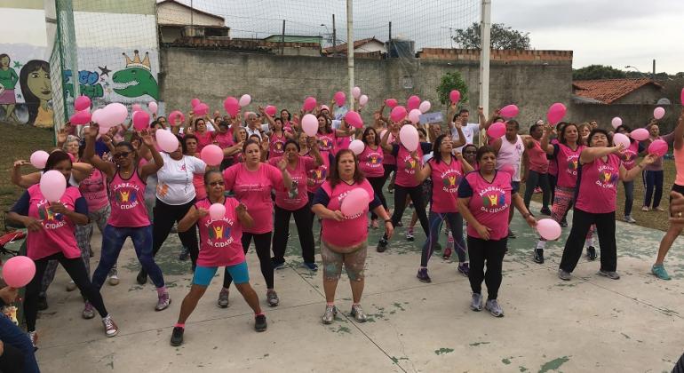 Mais de vinte membros da Academia da Cidade do bairro Confisco se exercitam vestidos de rosa, em homenagem a prevenção do câncer de mama.