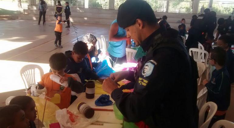 Grupo da Guarda Municipal faz ações contínuas de prevenção contra o crime nas 321 unidades da Rede Municipal de Ensino de BH. Foto: Divulgação PBH Guarda municipal orienta crianças sobre a montagem de pipas.