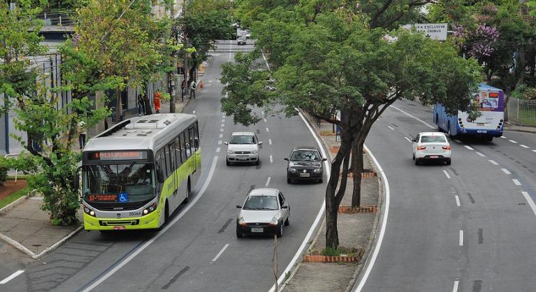 avenida com circulação de carros e pista exclusiva para ônibus, durante o dia. 