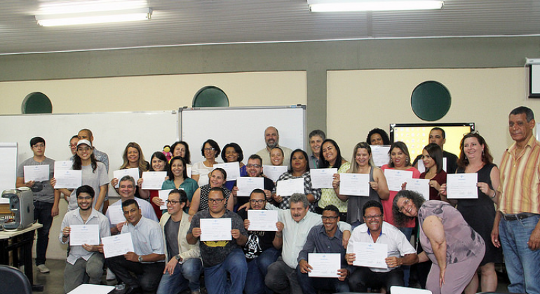 Projeto leva conhecimento para empreendedores de comunidades Empreendedores mostram certificado de curso.