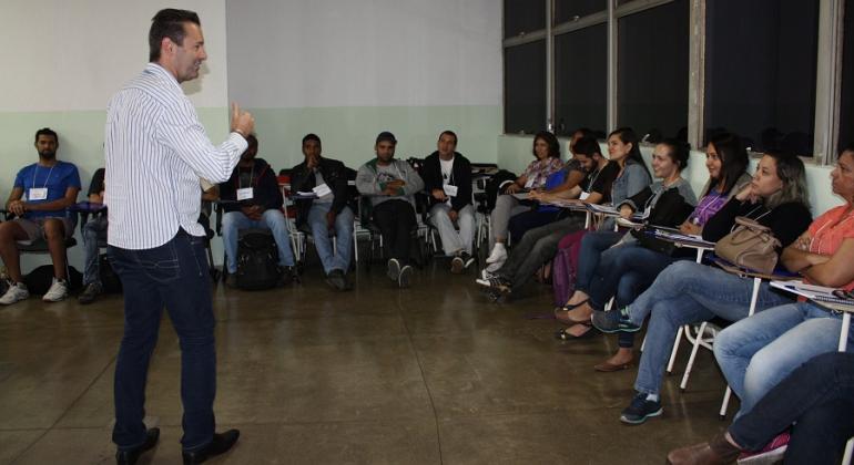 Agentes de combate a endemias participam de treinamento para atuar na saúde pública de Belo Horizonte. Foto: Leila Porto Homem faz palestra para mais de doze agentes de combate a endemias, sentados.