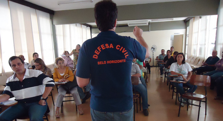 Foto ilustrativa: PBH capacita voluntários para prevenção de riscos nas chuvas Foto ilustrativa: Coronel Lucas de costas com camisa escrita "Defesa Civil - Belo Horizonte" realiza treinamento de para preparar os servidores da Prefeitura para o enfrentamento de eventuais problemas durante o período chuvoso, que se aproxima.