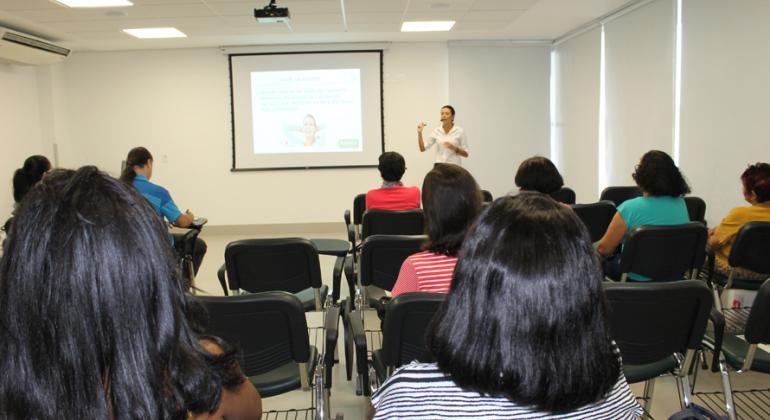 Cerca de 15 aposentados assistem à palestra sobre câncer de mama.