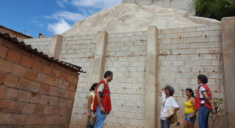 Comunidade Madre Gertrudes recebe obra de eliminação de risco geológico para 35 famílias feita pela Prefeitura por meio da Urbel. Foto: Divulgação PBH Diretor-presidente da Urbel, Claudius Vinicius Leite Pereira, junto a técnica da Urbel e três moradores da comunidade Madre Gertrudes junto ao muro de contenção.