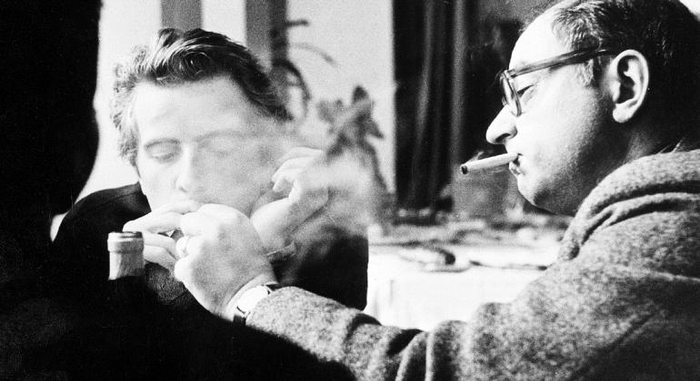 Jean Rouch e Edgar Morin no filme "Crônica de um Verão". Foto: Divulgação Cena do filme em preto e branco "Crônica de um Verão": em um salão, dois homens acendem seus cigarros.