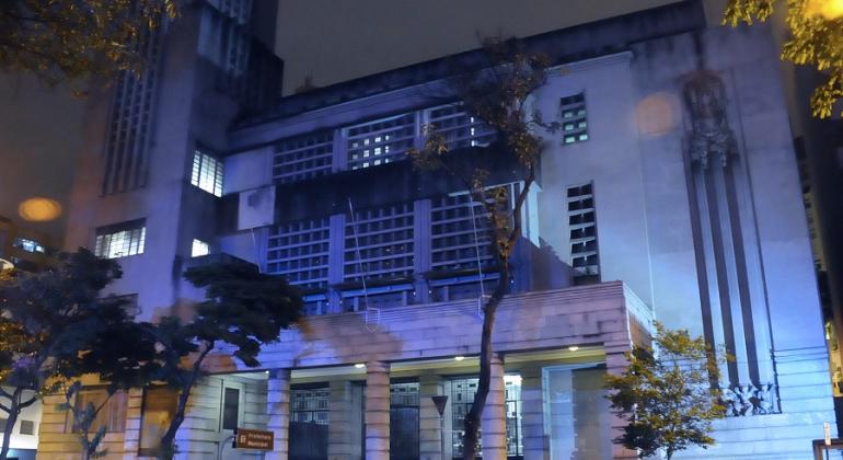 Fachada da Prefeitura de Belo Horizonte iluminada de azul durante a noite. 