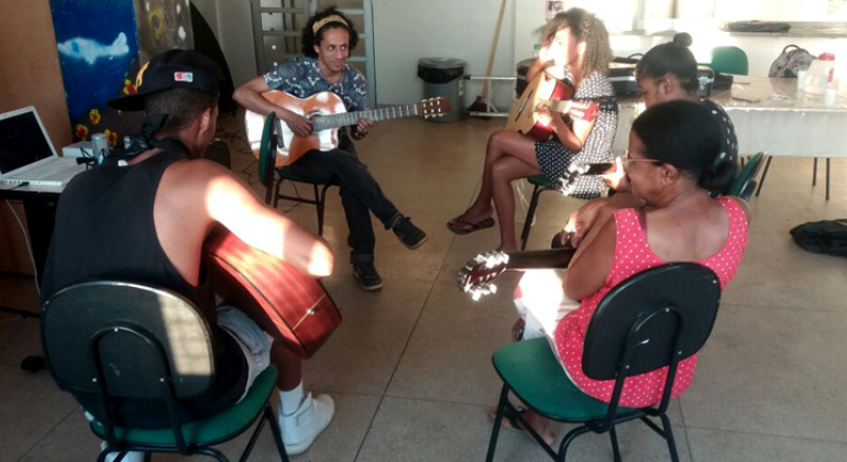 Centro Cultural Vila Santa Rita oferece programação ampla e diversificada em áreas como artes plásticas, dança, música, e teatro. Foto: Sabrina Dourado Seis pessoas, sentadas em uma sala, fazem oficina de violão.