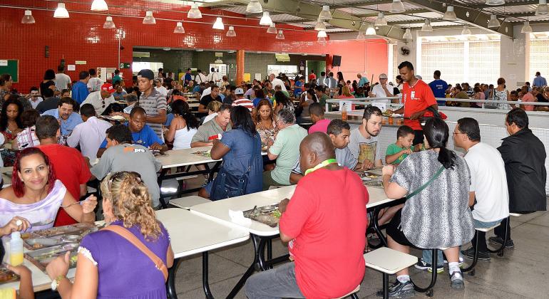Mais de vinte pessoas sentadas, almoçando no Restaurante Popular do Barreiro.