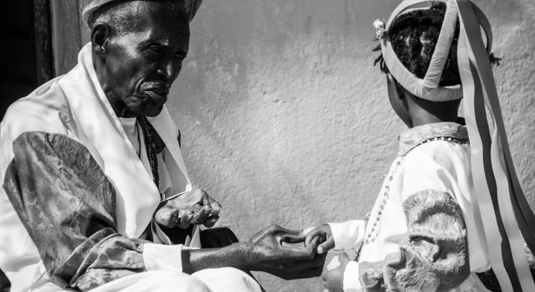 Mostra fotográfica tem o propósito de dar visibilidade à Comunidade dos Arturos, destacando sua beleza e a riqueza cultural. Foto: Fernando Diniz Senhor negro segura a mão de uma criança negra na Comunidade dos Arturos.