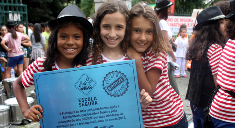 Foto: Leila Porto Três alunas seguram certificado Escola Segura.