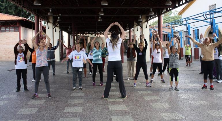 Instrutora faz ginástica com mais de quinza pessoas em Academia da Cidade.