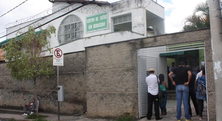 Fachada do Centro de Saúde São Bernardo com alguns cidadãos na entrada.