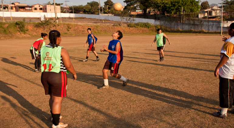 Adolescentes treinam futebol.