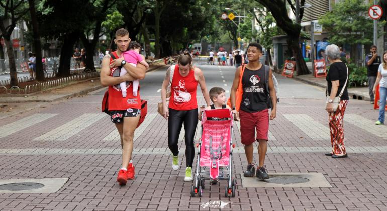 Confira os principais eventos gratuitos que acontecem em BH neste fim de semana, de 1º a 3 de dezembro. Foto: Amira Hissa/PBH Dois homens, uma mulher e duas crianças caminham com um carrinho de bebê na Savassi.