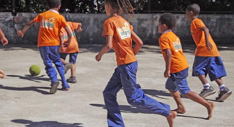 As crianças jogam futebol na escola