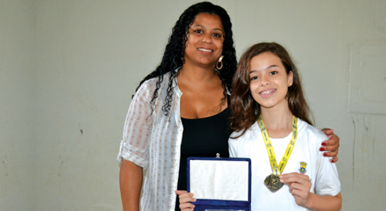 Estudantes de escolas municipais do Barreiro ganharam medalhas de ouro na Olimpíada Brasileira de Matemática. Foto: Kátia Gaspar Estudantes mostram medalhas e certificado.