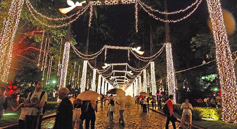 Luzes de Natal da Praça da liberdade e cidadãos andando na praça, alguns deles com guarda-chuva. Foto ilustrativa, do Natal de 2016.